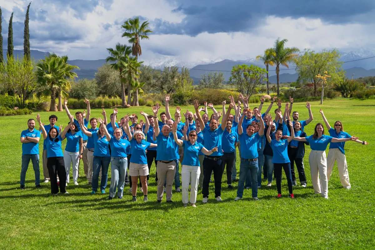 A large team celebrating together on the lawn in Marrakech