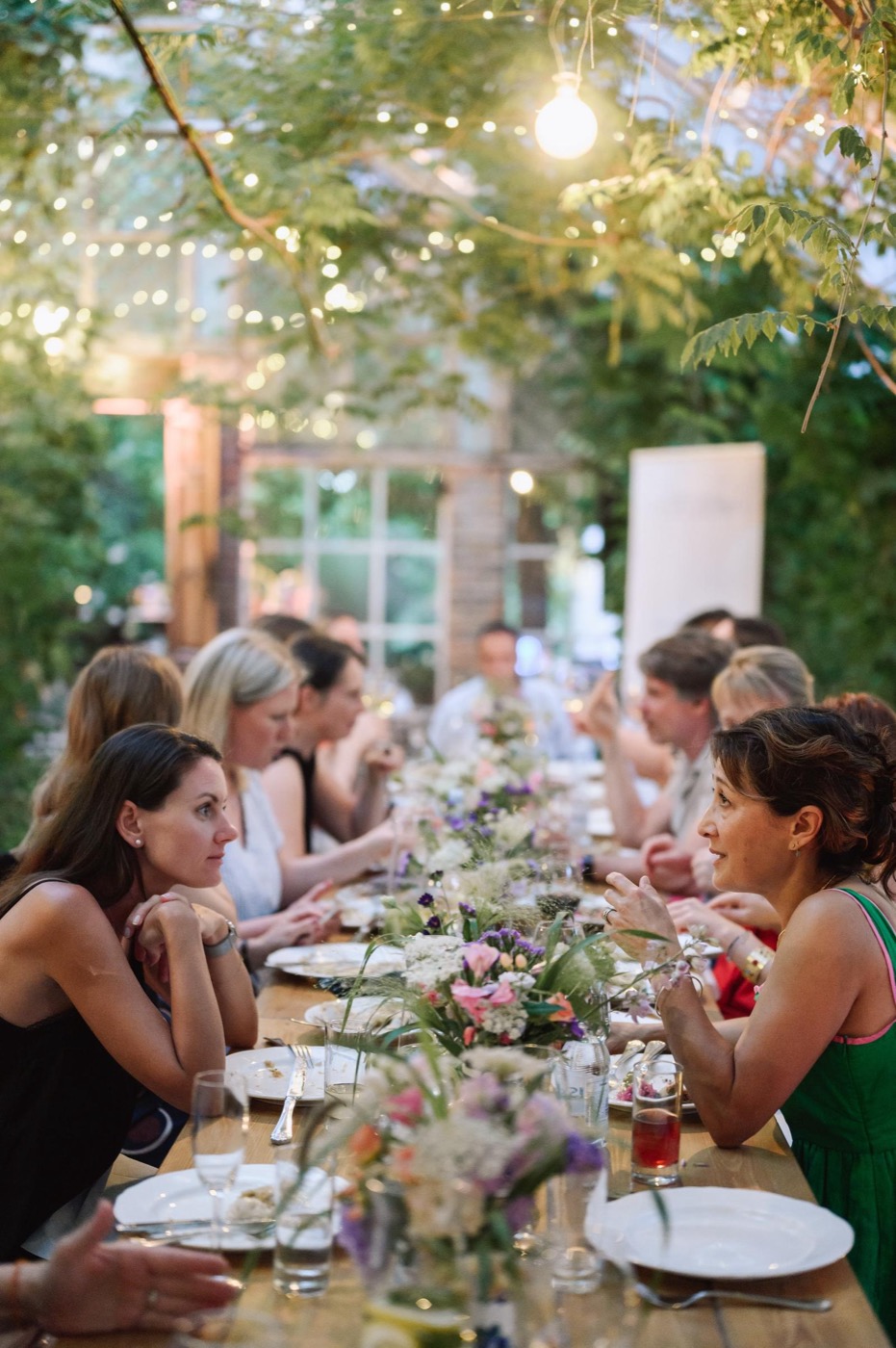 Participants sharing dinner at a long garden table during the Summer School
