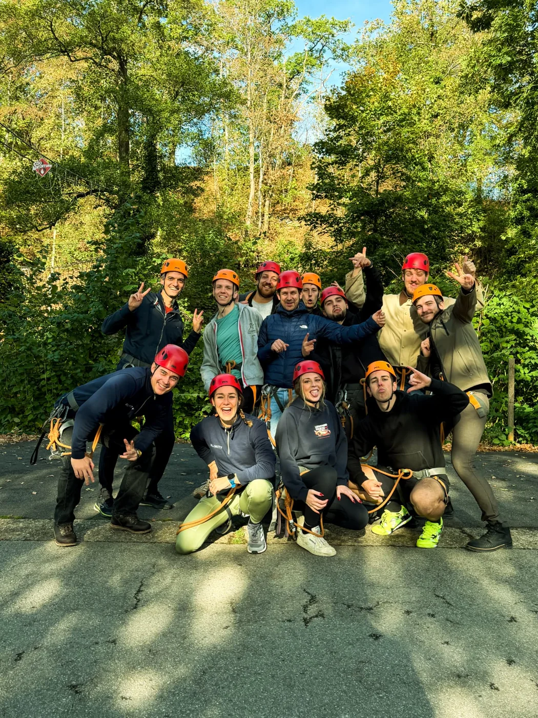 Elimity teammates posing in helmets and climbing harnesses in the forest