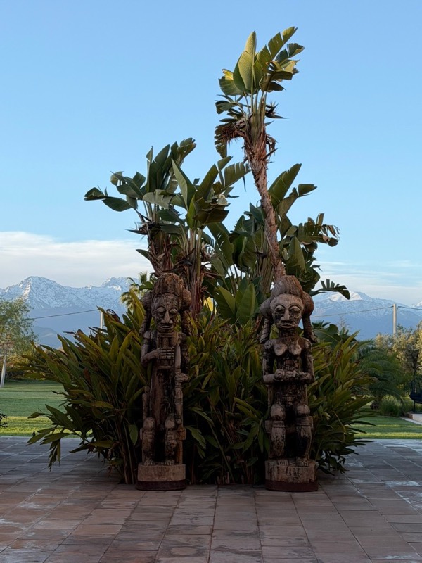 Wooden statues in front of a mountain landscape