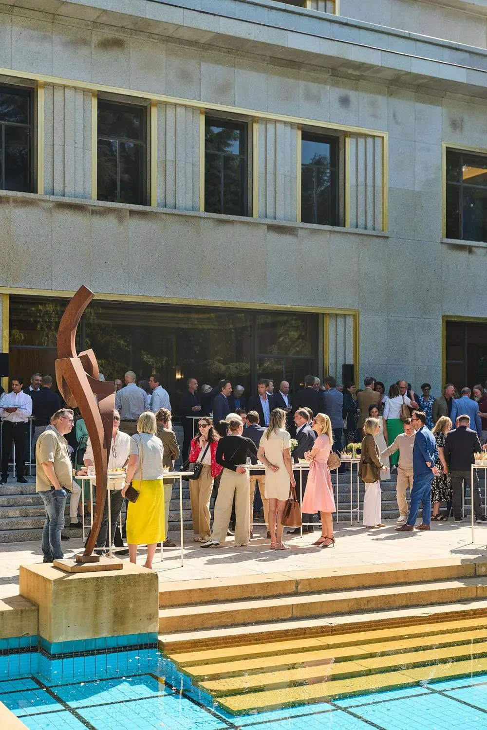 Guests mingling at an outdoor reception beside a pool
