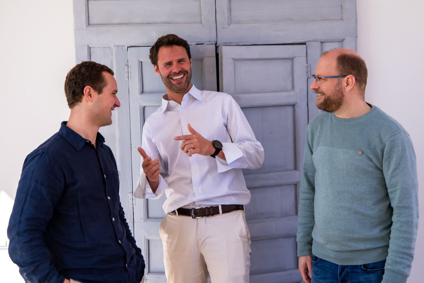 Three colleagues laughing together during an offsite